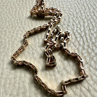 gold chain necklace on a textured light gray surface