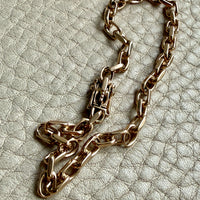 14k Gold vintage biker chain bracelet on a textured light gray background