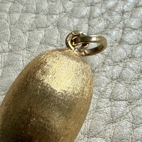 Gold pendant on a textured gray background