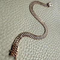 gold chain necklace on a textured gray surface