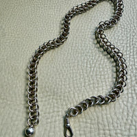 Silver chain with a clasp on a textured gray background