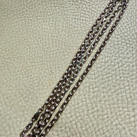 Silver chain on a textured beige surface