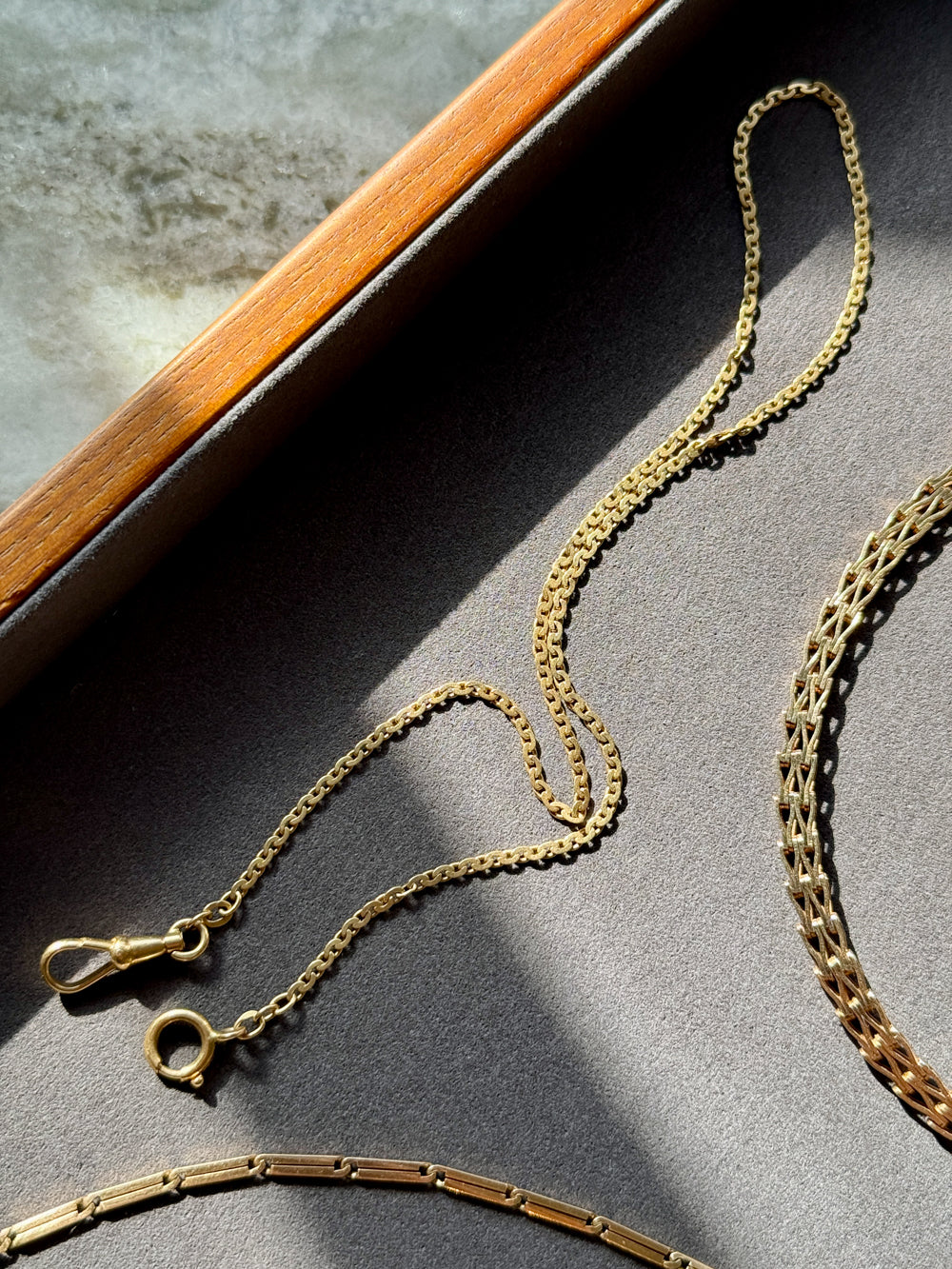 Gold chain necklace on a textured surface