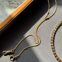 Gold chain necklace on a textured surface