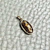18k Gold owl pendant with a detailed design on a textured gray surface