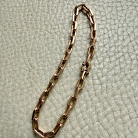 18k Gold chain bracelet on a textured light green surface