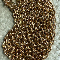 Gold chain on a textured light background