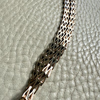 gold chain necklace on a textured gray surface