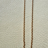 Gold chain on a textured light gray background
