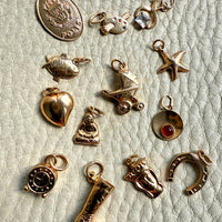 Collection of various gold charms on a textured surface