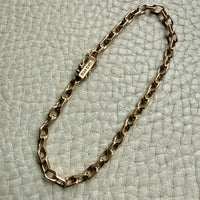 14k Gold vintage biker chain bracelet on a textured light gray background
