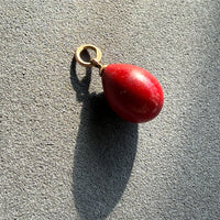 red purpurin egg pendant on gray background