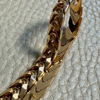 18 Gold link bracelet on a textured gray surface