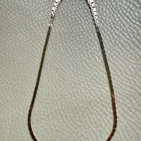 gold Necklace on a textured gray surface