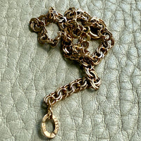 Gold chain necklace on a textured light green background