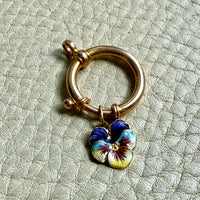 antique 18k gold large bolt clasp with a blue and yellow flower charm on a textured light gray background penelopepenelope.com