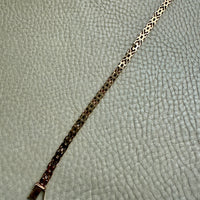 18k Gold bracelet on a textured gray surface