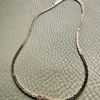 gold necklace on a textured surface