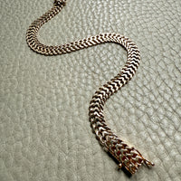gold chain bracelet on a textured gray surface