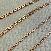 gold chain necklace on a textured gray surface