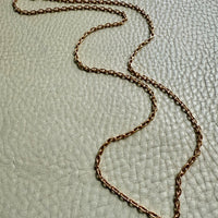 18k gold chain necklace on a textured light gray background