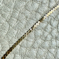 Gold chain on a textured light gray surface