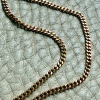 Gold chain on a textured light blue surface