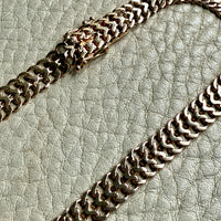 gold chain on a textured light gray surface