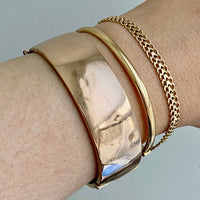 A solid gold hinged bangle made in 1978 in Sävsjö, Sweden. Solid bangles like this are rare finds! What I love about them is that they cannot dent - this style is a solid bar of gold! This amazing vintage Scandinavian 18k gold bangle is oval shaped with a femme half-round cross section. Interior of the oval measures 2 inches (50mm) x 2.4 inches (60mm) and opens with a well working and beautiful hinge. She weighs an excellent 18.2g
