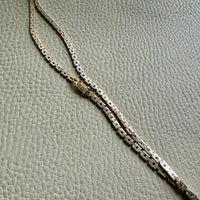 14k Gold vintage chain necklace on a textured gray background