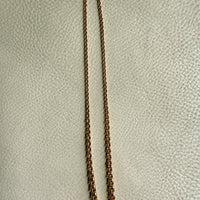 18k Gold vintage graduated rolo chain necklace on a textured beige surface
