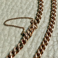 antique 18k Rose gold curb chain bracelet on a textured beige surface