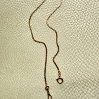 18k Gold virola link chain on a textured light gray surface