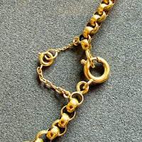 Gold chain necklace on a textured gray surface