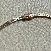 gold chain clasp on a textured gray surface