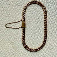 18k vintage Gold curb chain bracelet on a textured light gray surface