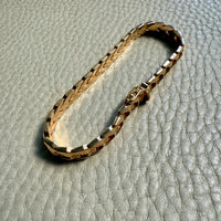 18 Gold link bracelet on a textured gray surface