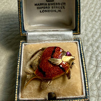 Gold fish brooch in an open jewelry box with Mappin & Webb branding.