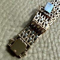 18k gold bracelet clasp on a textured surface