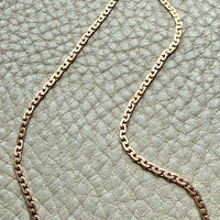 18k Gold virola link chain on a textured light gray surface