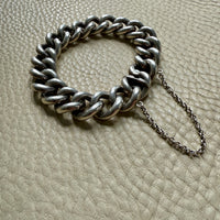 Silver chain bracelet on a textured beige surface