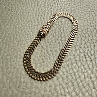 gold chain necklace on a textured gray surface