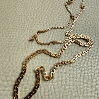 vintage 18k Gold virola link necklace on a textured light beige surface penelopepenelope.com