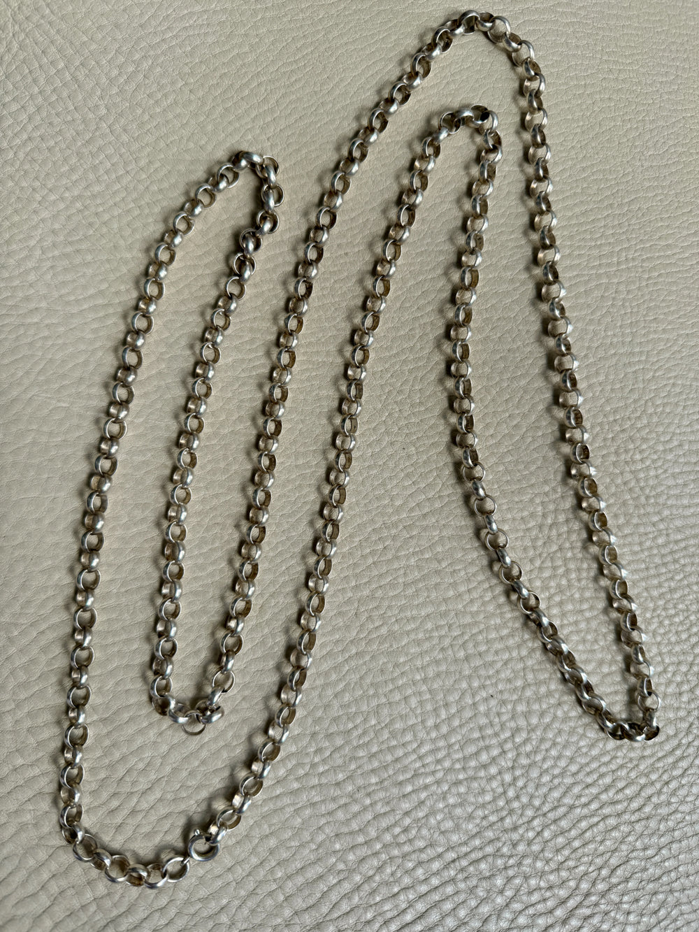 Silver chain on a textured gray surface