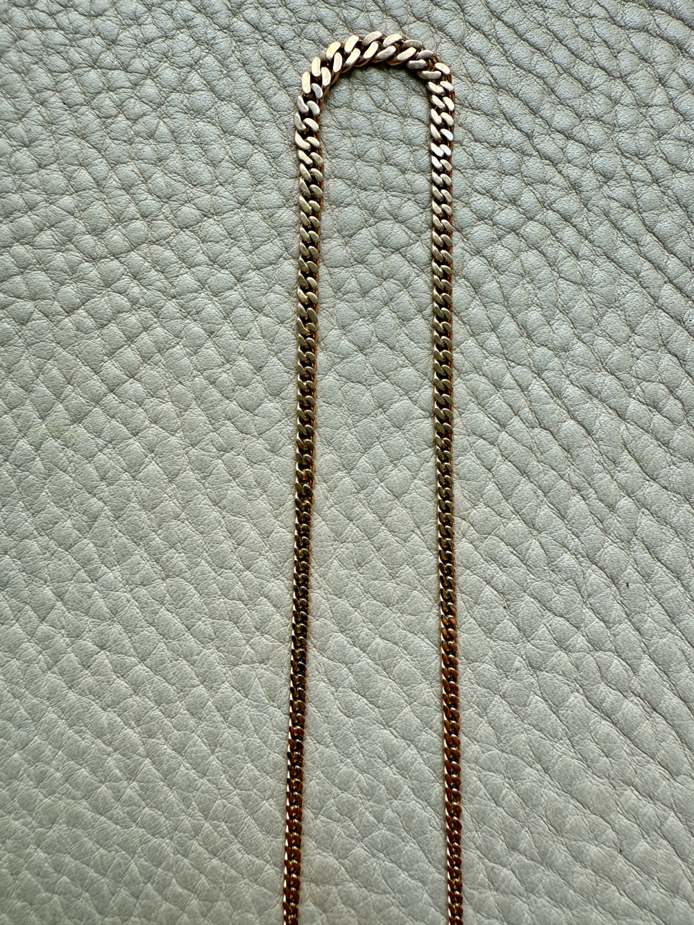 Gold chain on a textured light blue surface