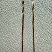Gold chain on a textured light blue surface