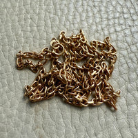 Gold chain on a textured light gray surface