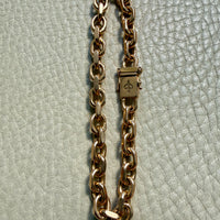 18k gold vintage biker link chain bracelet on gray textured surface