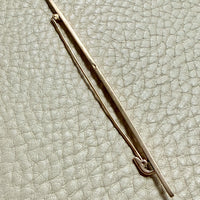 18k gold antique brooch on a textured beige background
