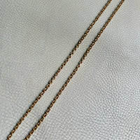 vintage 18k yellow gold biker link chain necklace on a textured light gray surface